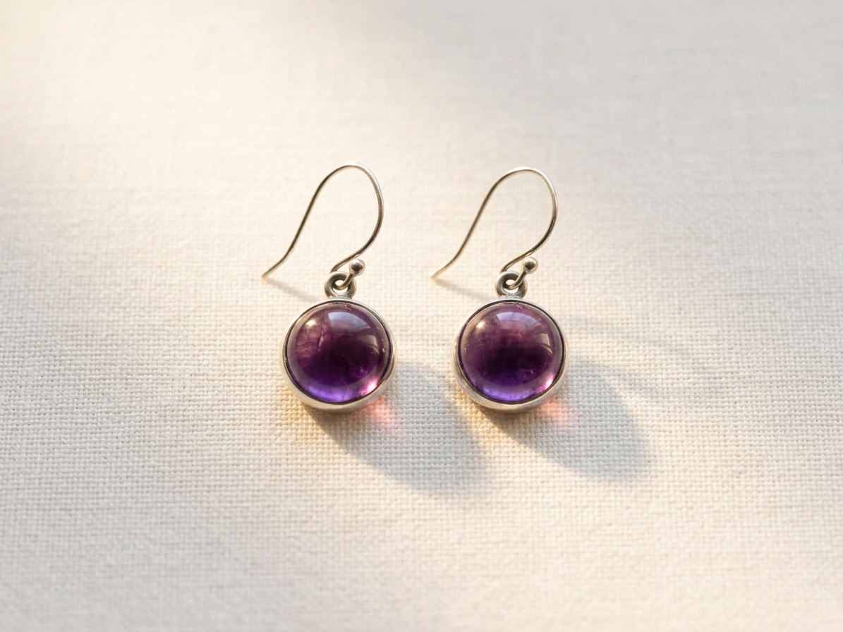 The same earrings on pale linen in soft directional light